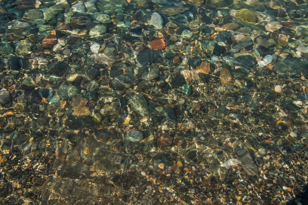 Stones in clear water of sea, water and stones background