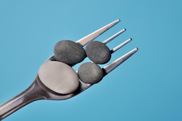 Stones on a fork, a symbol of heavy, unhealthy food.