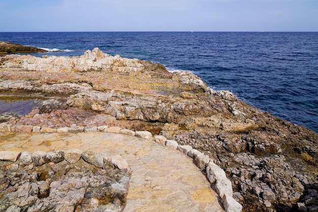 Stones pathway in rocks access to beach sea in coast JuanlesPins in Antibes France