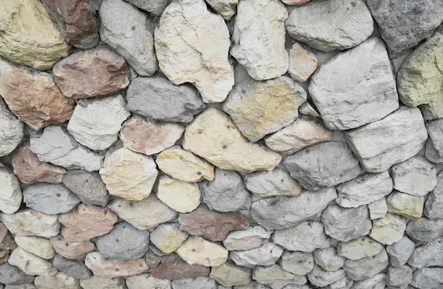 Stones and pebbles on gray wall