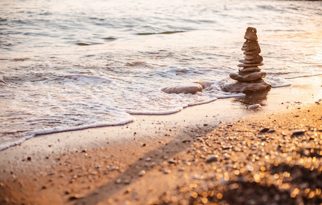 Stones of the pyramid on the beach symbolize the concept of Zen