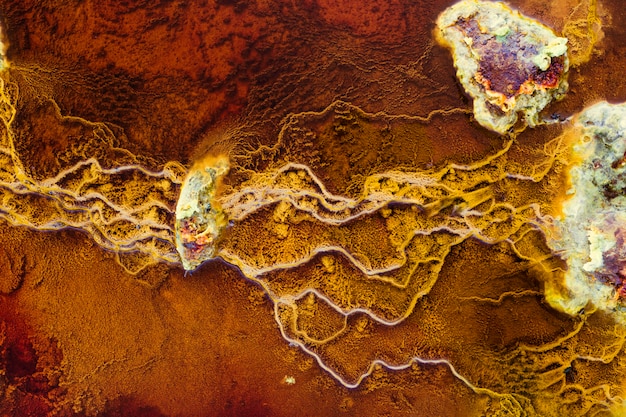 Stones in red waters connected by yellow stromatolites