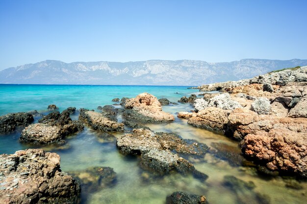 Stones on a surface of blurred sea with mountain view