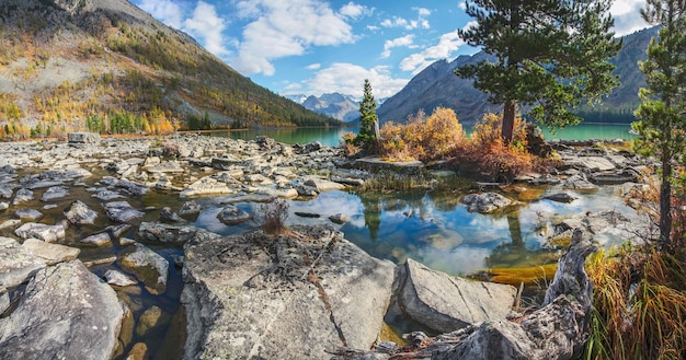 Stony shore of a mountain lake autumn view sunny