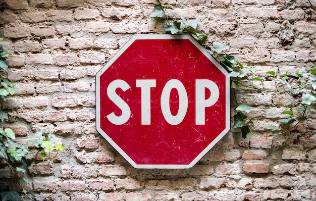 Stop road sign attached to brick wall