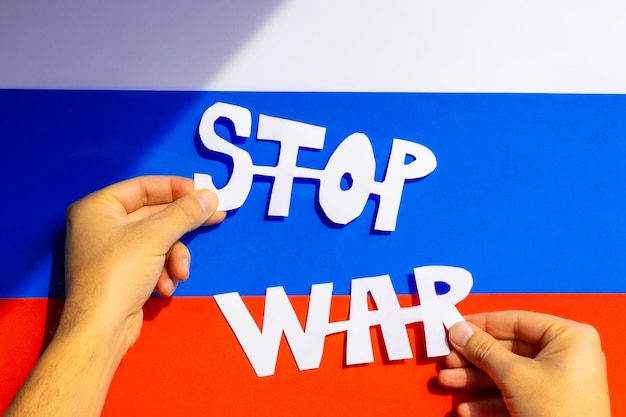 Stop war conflict between Ukraine and Russia A man's hands holding a handmade cutout with a stop war slogan