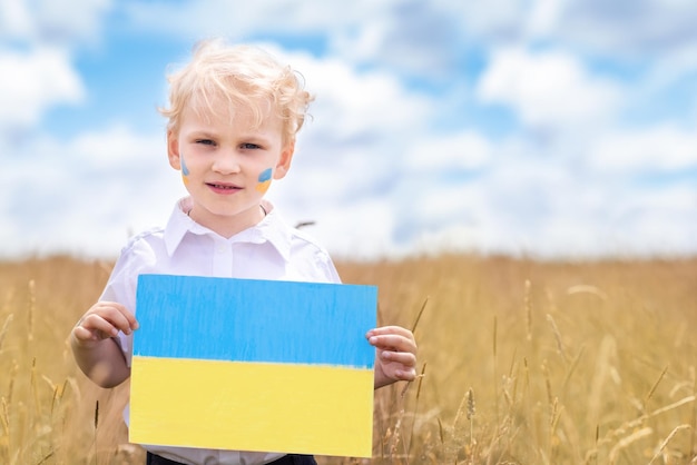 Stop War in Ukraine Ukrainian boy with Ukrainina flag yellow and blue stands against war