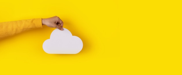 Storage cloud in hand over yellow background, storage concept, panoramic layout