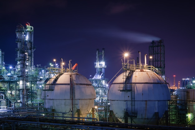 Storage sphere tanks in oil and gas refinery plant with night, Glitter lighting of petrochemical plant, Industrial plant with ultraviolet sky 