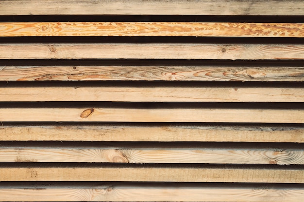 Photo storage timber. lumber yard. stock of timber wood construction in warehouse.planks of wood stacked neatly on the shelves in the hardware store.