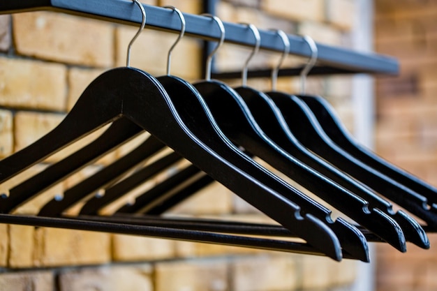 Store concept sale design empty hangers Wooden coat hanger clothes Fashionable different types of hanger Wood hangers coat Many wooden black hangers on a rod