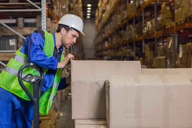 Storehouse worker checking boxes with merchandise in warehouse