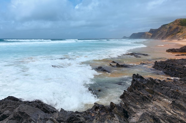 Storm on Castelejo beach with black schist cliffs (Algarve, Portugal).