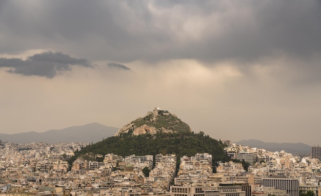 Storm clouds above Lycabettus hill with the city of Athens surrounding it