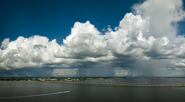 Stormy clouds forming from evaporating humidity of ocean water before thunderstorm over traffic bridge connecting Punta Gorda and Port Charlotte over Peace River Bad weather conditions for driving