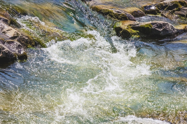 Stormy stream of water near pebbles in a mountain river