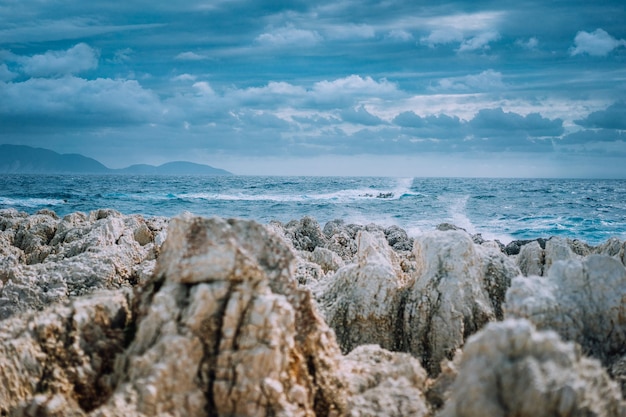 Stormy weather on the rocky coastline Waves breaking against rocky shore Dramatic cloudscape