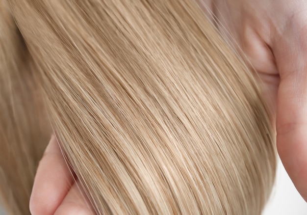 A strand of blond hair on a white background Closeup