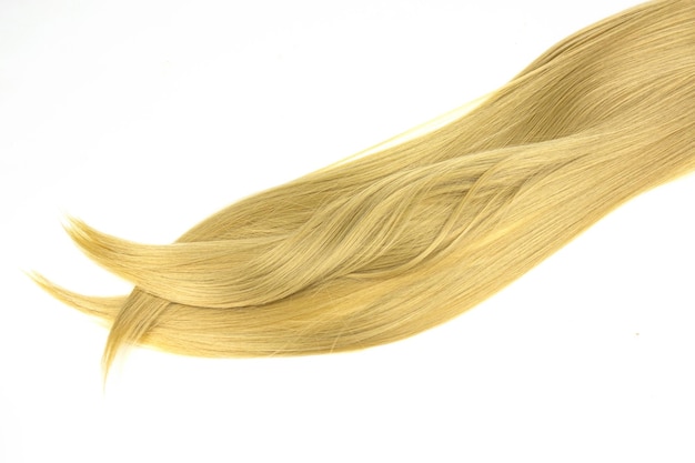 Strand of blond silky hair on a white background Blond hair in line shape on white background