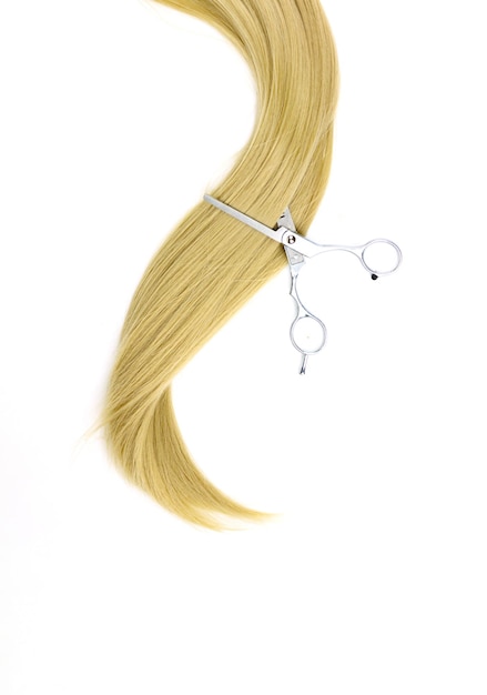 Strand of blonde hair with Hairdresser scissors hair care Hair extensions materials and cosmetics hair care wig