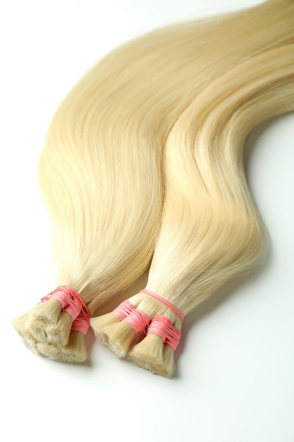 Strands of blond hair on white background