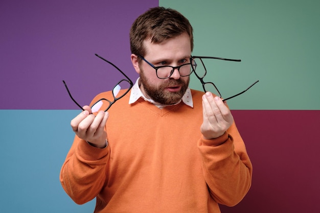 Strange man in a stupor selects and compares glasses he has to solve a difficult question