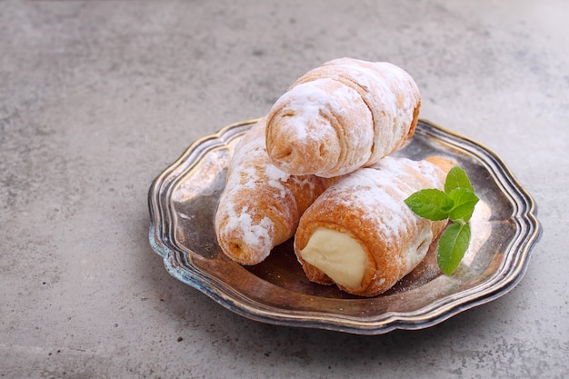 "Straw" cake filled with cream, decorated with sugar powder and mint leaves