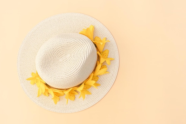 Straw hat with with yellow lily flowers on pastel background Stylish retro design template Yellow background Summer fashion concept Copy space Flat lay style