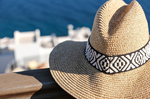 Straw hat on a wooden terrace with sea view