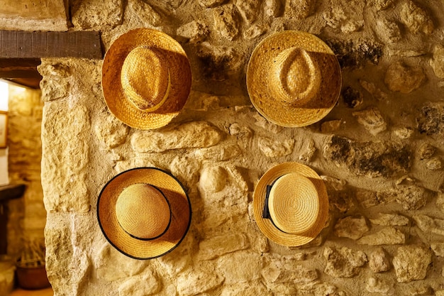 Straw hats hanging on the wall of an old retrostyle house reminiscent of times gone by