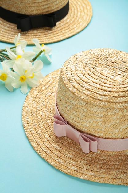 Photo straw hats with spring flowers on mint surface