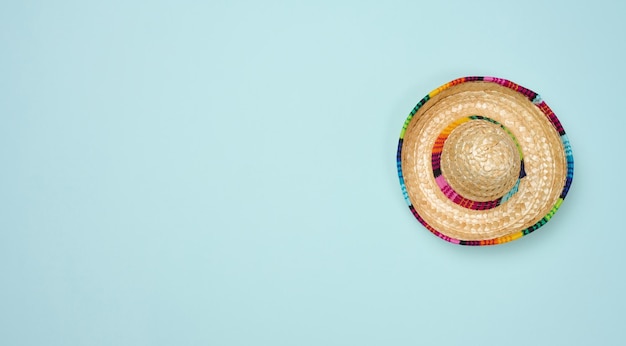 Straw mexican hat on blue background top view