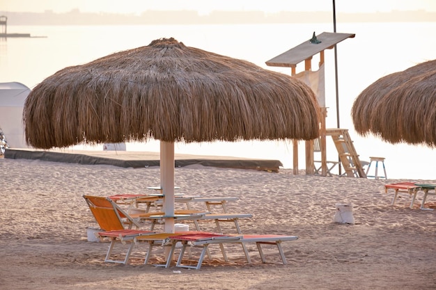 Straw shade umbrella in sea tropical region against blue vibrant sky in summer