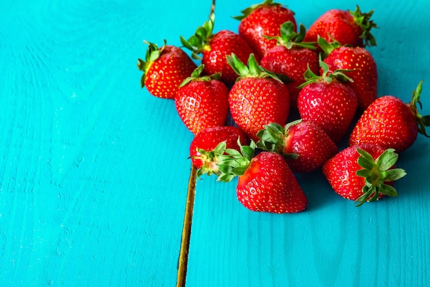 Strawberries on the blue wooden background Spring berries