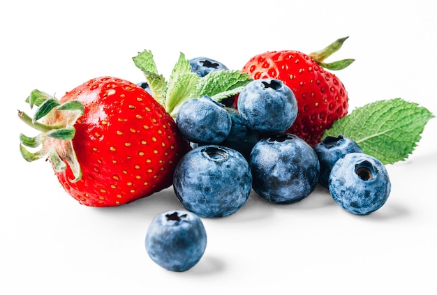 Strawberries blueberries and mint leaves isolated on white Forest fruits