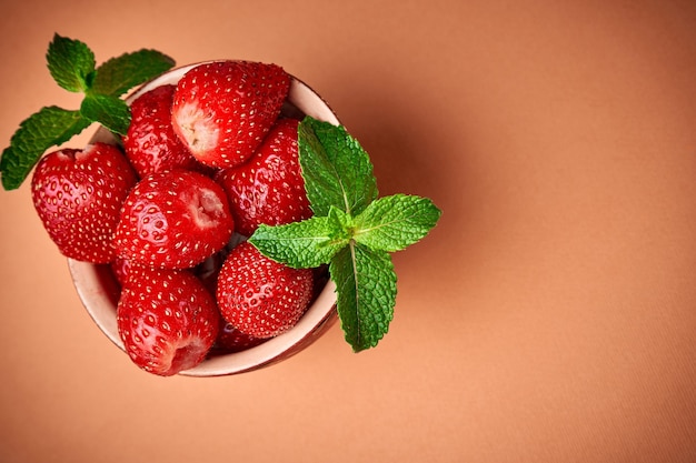 Strawberries in bowl on orange Place for text