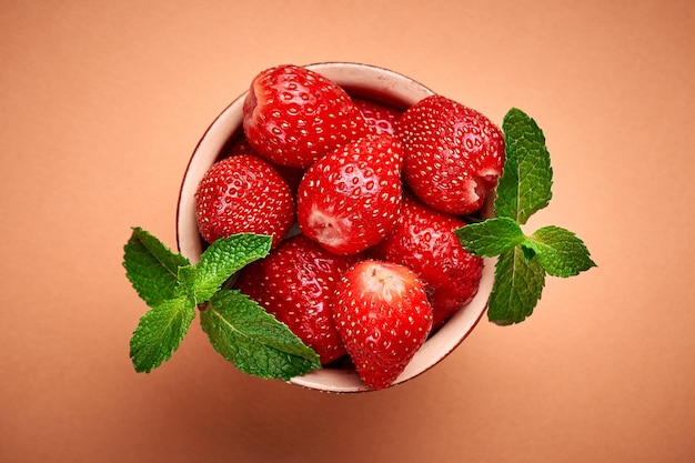 Strawberries in bowl on orange Place for text