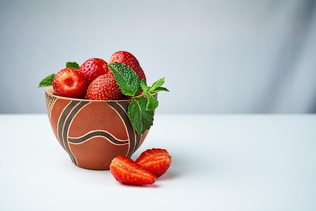 strawberries in a ceramic bowl on a light background