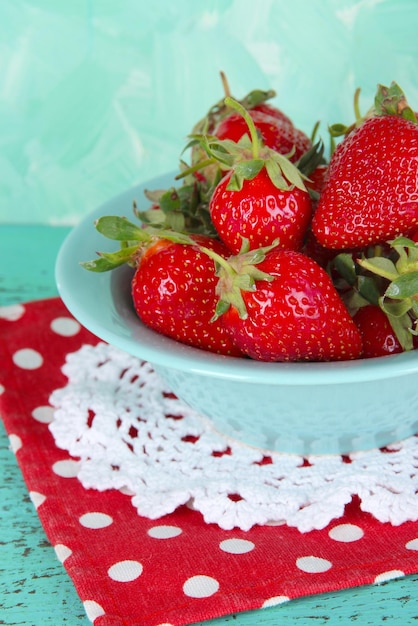 Strawberries in plate on napkin on blue background