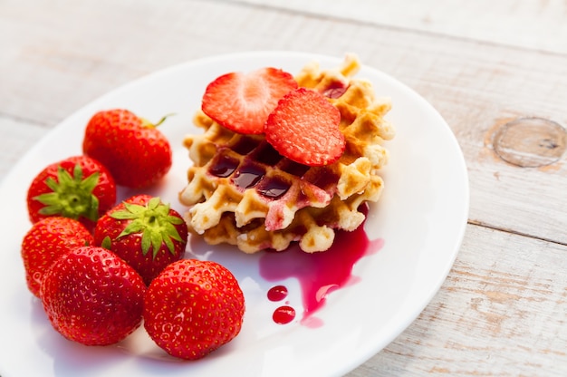 Strawberries and wafer on a white plate