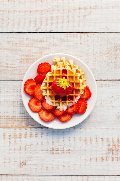 Strawberries and wafer on a white plate