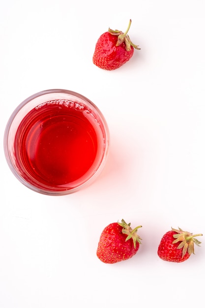 Strawberries with compote drink in glass isolated on white background, top view