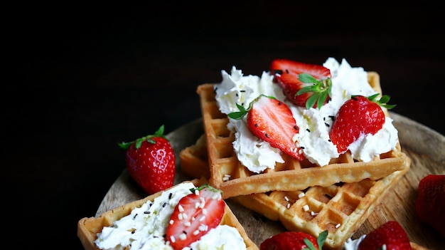 Strawberries with cream on Viennese waffles Summer dessert with strawberries