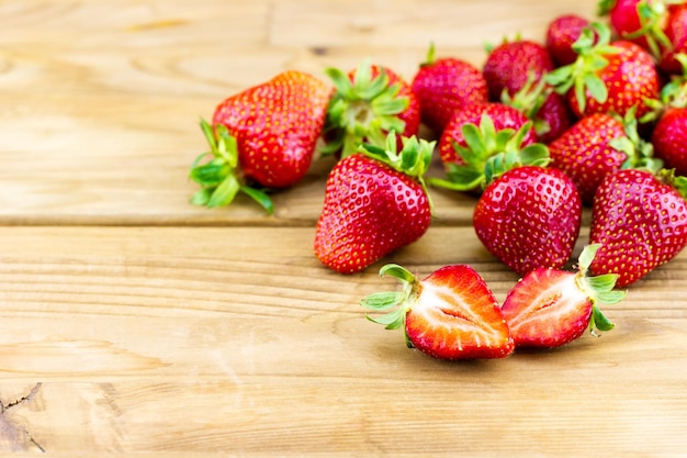 Strawberries on a wooden table with one cut in half