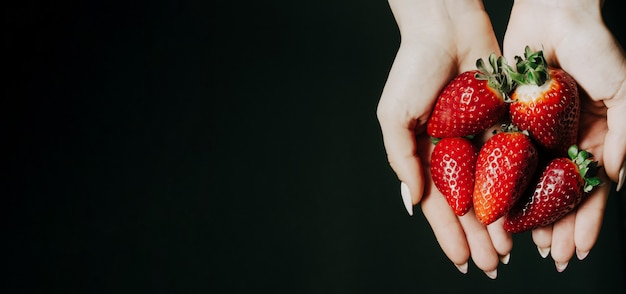 Strawberry berries in women 's hands.