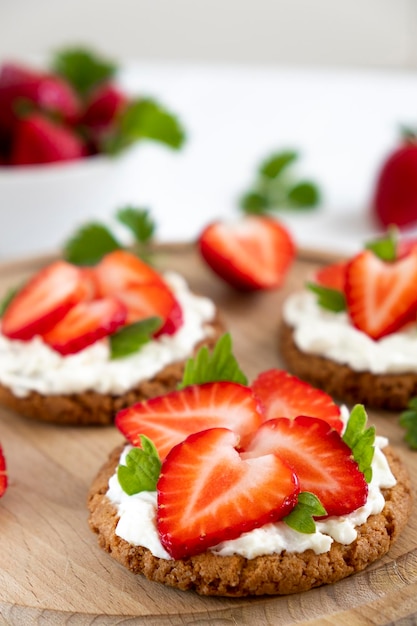 Strawberry bruschetta on rye bread with cottage cheese and mint Healthy snack keto diet or dieting concept Recipe of vegan food for everyday cooking