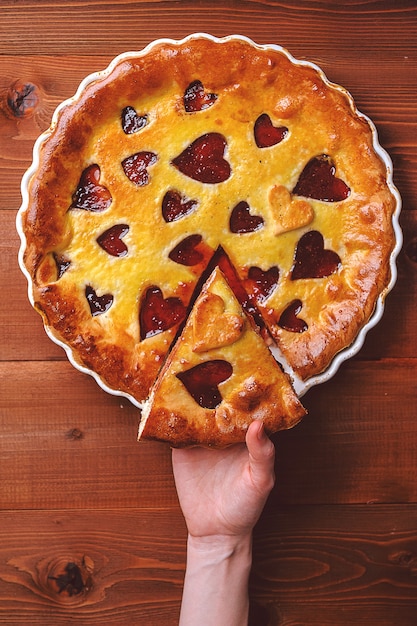 Strawberry cake for Valentine's Day with hearts on a wooden background