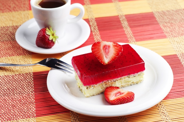 Strawberry cake with poppy and cup of coffee