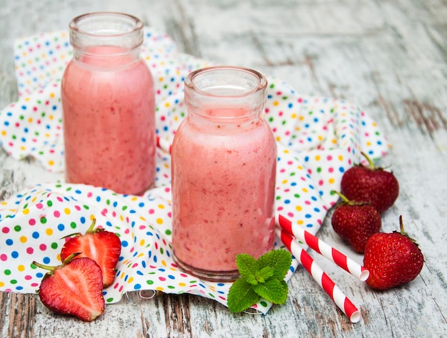 Strawberry fruit smoothies with fresh strawberries on a old wooden background