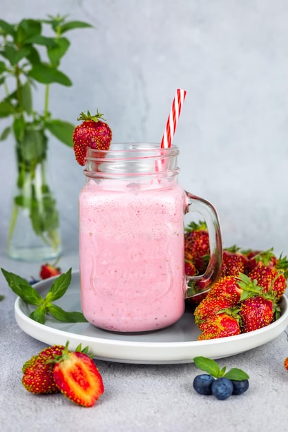 Strawberry lassi or milkshake on gray background Healthy milky Indian drink